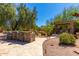 An outdoor kitchen with stone counters and seating area offer an ideal space for entertaining outdoors at 8649 S Willow Dr, Tempe, AZ 85284