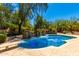 A gorgeous pool features a diving board, a stone waterfall, and a built-in bar at 8649 S Willow Dr, Tempe, AZ 85284