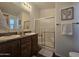 Bathroom with double sinks, wooden cabinets, framed mirror, and enclosed shower at 8700 E University Dr # 1947, Mesa, AZ 85207