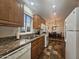Charming kitchen with wood cabinets, granite counters, and stainless sink, open to dining area at 8700 E University Dr # 1947, Mesa, AZ 85207