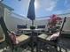 Cozy patio featuring comfortable seating around a metal table with a decorative sun umbrella and flowering plants at 8700 E University Dr # 1947, Mesa, AZ 85207