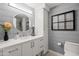 Bathroom with a white vanity, stylish mirror, and a toilet, complemented by gray shiplap walls at 9450 E Becker Ln # 2019, Scottsdale, AZ 85260