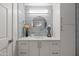 Bathroom showcasing a modern vanity with a round mirror, complemented by gray shiplap walls at 9450 E Becker Ln # 2019, Scottsdale, AZ 85260