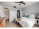Bedroom with light walls, window, ceiling fan, and closet and bathroom entrances at 9450 E Becker Ln # 2019, Scottsdale, AZ 85260