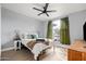 Bedroom featuring a cozy bed, ceiling fan, and a window with green curtains, creating a relaxing ambiance at 9450 E Becker Ln # 2019, Scottsdale, AZ 85260