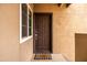 Welcoming front door with 'Welcome' mat and neutral siding at 9450 E Becker Ln # 2019, Scottsdale, AZ 85260