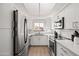 Bright white kitchen features stainless steel appliances, quartz countertops, and a marble backsplash at 9450 E Becker Ln # 2019, Scottsdale, AZ 85260