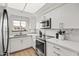 Contemporary white kitchen with stainless steel appliances, quartz countertops, and a bright window at 9450 E Becker Ln # 2019, Scottsdale, AZ 85260