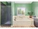 Relaxing bathroom featuring a soaking tub with a window view and a separate glass-enclosed shower at 10500 E Mission Ln, Scottsdale, AZ 85258