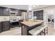 Modern kitchen featuring stainless steel appliances, a kitchen island, and a breakfast bar at 10500 E Mission Ln, Scottsdale, AZ 85258