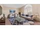 A cozy living room featuring plush seating, a glass coffee table, and a large arched window for ample natural light at 10500 E Mission Ln, Scottsdale, AZ 85258