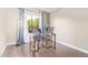 Bright office space with hardwood floors, a glass desk, and a large window showcasing the outdoor greenery at 10500 E Mission Ln, Scottsdale, AZ 85258