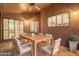 Covered patio featuring a wooden dining set, textured walls, and outdoor lighting, perfect for entertaining at 10500 E Mission Ln, Scottsdale, AZ 85258