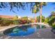 Sparkling pool surrounded by colorful plants and palm trees creates a backyard paradise at 10500 E Mission Ln, Scottsdale, AZ 85258