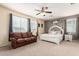 Comfortable bedroom featuring a sitting area, ceiling fan and a large window at 10535 E Simone Ave, Mesa, AZ 85212