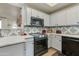 Bright kitchen with white cabinets, black appliances and decorative tile backsplash at 11680 E Sahuaro Dr # 1059, Scottsdale, AZ 85259