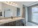 Beautiful bathroom featuring double sinks, granite countertops, a large mirror, and a modern walk-in shower at 1201 E Gemini Dr, Tempe, AZ 85283