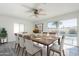 Bright dining room with ceiling fan, large window view of backyard pool, and 8 chair dining set at 1201 E Gemini Dr, Tempe, AZ 85283