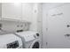 Efficient laundry room features modern washer and dryer, upper cabinets, and a storage closet at 1201 E Gemini Dr, Tempe, AZ 85283