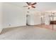 Spacious living room featuring neutral carpet, tile accents, and open layout connected to the kitchen at 1235 W Jeanine Dr, Tempe, AZ 85284