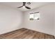 Bright bedroom features wood-look floors, a modern ceiling fan, and a view out of a window at 1326 E Catalina Dr, Phoenix, AZ 85014