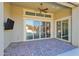 Covered back patio features brick pavers, ceiling fan, and sliding glass doors at 13734 W Harvest Ave, Litchfield Park, AZ 85340