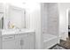 Bright bathroom featuring a white vanity, tub and shower combination, and decorative rug at 13734 W Harvest Ave, Litchfield Park, AZ 85340
