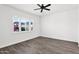 Bright bedroom features wood-look tile floors and a modern ceiling fan at 13734 W Harvest Ave, Litchfield Park, AZ 85340