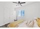 Bright bedroom featuring a ceiling fan, wood floors, plantation shutters, and neutral decor at 13734 W Harvest Ave, Litchfield Park, AZ 85340