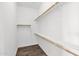 Spacious walk-in closet with ample shelving and wooden racks for maximum storage and organization at 13734 W Harvest Ave, Litchfield Park, AZ 85340