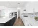 A modern kitchen with an island, stainless steel appliances, and white and dark cabinets at 13734 W Harvest Ave, Litchfield Park, AZ 85340