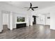 Large, open living area with wood-look tile flooring, a built-in bar, and a media center at 13734 W Harvest Ave, Litchfield Park, AZ 85340