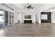 Spacious living room featuring wood flooring, built-in shelving, and a sliding glass door for natural light at 13734 W Harvest Ave, Litchfield Park, AZ 85340