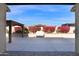 A spacious backyard patio features a cozy pergola, set against a backdrop of blooming bougainvillea at 13734 W Harvest Ave, Litchfield Park, AZ 85340