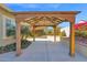 An inviting wooden pergola stands in the backyard, surrounded by lush green foliage and colorful flowers at 13734 W Harvest Ave, Litchfield Park, AZ 85340