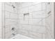 This stunning shower features elegant marble tile and a built-in niche for storage at 13734 W Harvest Ave, Litchfield Park, AZ 85340