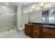 Bathroom featuring double sink vanity with dark wood cabinets and a glass-enclosed shower at 1400 E Bethany Home Rd # 27, Phoenix, AZ 85014