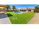 Expansive backyard featuring a pool, lush green lawn, palm trees, and outdoor living areas for ultimate relaxation and enjoyment at 1439 N Spencer --, Mesa, AZ 85203