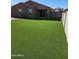 Spacious backyard featuring lush artificial grass and a block wall fence at 1602 W Central Ave, Coolidge, AZ 85128