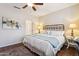 Cozy bedroom features a ceiling fan, warm lighting and comfortable queen size bed with decorative pillows at 17228 N Estrella Vista Dr, Surprise, AZ 85374