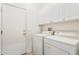 Laundry room with white washer and dryer and plenty of white cabinet storage at 17228 N Estrella Vista Dr, Surprise, AZ 85374