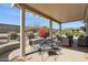 Covered patio with outdoor seating and a view of the landscaped backyard with desert foliage at 17228 N Estrella Vista Dr, Surprise, AZ 85374