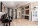 Open floor plan of a living room featuring a fireplace, built in shelving and a baby grand piano at 20966 N 84Th Ln, Peoria, AZ 85382