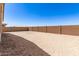 A view of a spacious backyard featuring a block wall fence and desert landscaping at 21960 E Saddle Ct, Queen Creek, AZ 85142