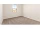 A bright bedroom with neutral carpet, fresh white walls, and a window offering ample natural light at 21960 E Saddle Ct, Queen Creek, AZ 85142