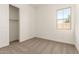 Cozy bedroom with a large window, neutral-toned carpet, and a spacious closet with open door at 21960 E Saddle Ct, Queen Creek, AZ 85142