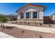 The front exterior features beautiful stone accents and desert landscaping at 21960 E Saddle Ct, Queen Creek, AZ 85142