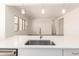 Close up on a kitchen sink with stainless steel faucet, white countertop, and views of the open floor plan at 21960 E Saddle Ct, Queen Creek, AZ 85142