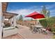 Relaxing backyard featuring a covered patio, dining set with umbrella, and easy to maintain landscaping at 22651 E Via Del Verde --, Queen Creek, AZ 85142