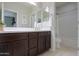 Bathroom featuring dark cabinetry with a framed mirror and a combination shower and tub at 22651 E Via Del Verde --, Queen Creek, AZ 85142
